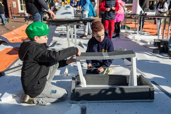 Bouwploeg HIK leert kinderen op de markt carnavalswagen bouwen.