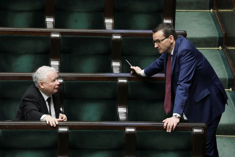 PiS-leider Jaroslaw Kaczynski and Polish en premier Mateusz Morawiecki overleggen met elkaar tijdens een zitting van het Poolse parlement over de maatregelen in verband met het coronavirus.. Beeld REUTERS