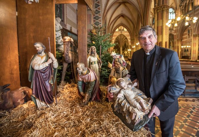 Vicaris Ad van der Helm maakt de kerststal in de St.Jacobuskerk compleet.