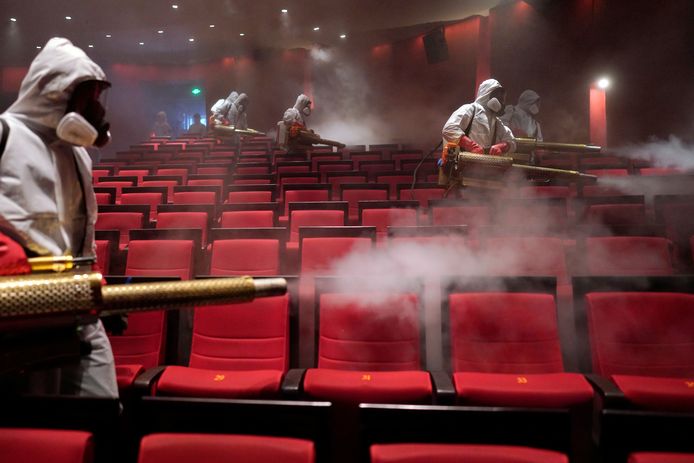 Reinigers met dampkanonnen ontsmetten een bioscoopzaal in Wuhan (foto uit april 2020).
