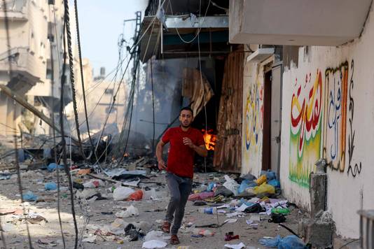 Een Palestijnse man rent weg in Gaza
