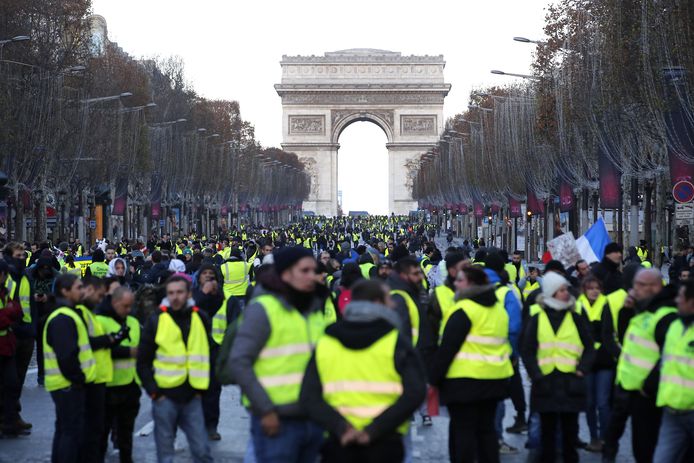 Demonstranten in gele hesjes lopen over de Champs Elysees, waar ze aan het einde worden tegengehouden.