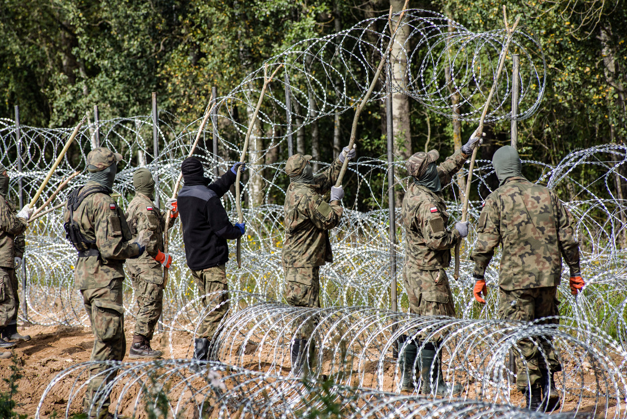 Poolse soldaten hangen scheermesdraad aan de grens in Wojnowce. Beeld ZUMA Press