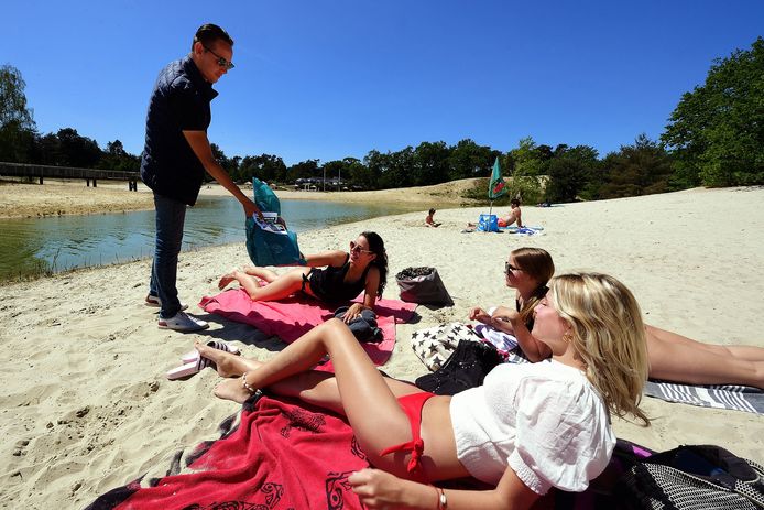 De veertienjarige meiden Zoë Haast, Ilse van Tilburg en Sofie Ruedisueli (vlnr) krijgen een vuilniszak met flyer uitgebreid. Ze erkennen dat er veel troep wordt achtergelaten op het strand bij De Bergse Heide.