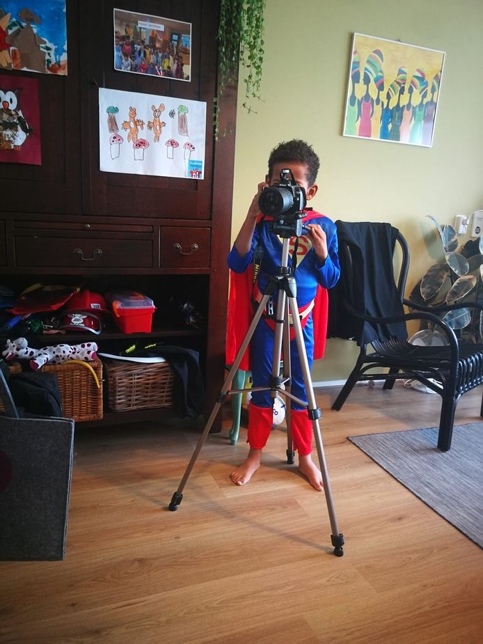 Isai, in zijn superman-outfit, met een eigen camera. Het statief ‘leende’ hij van zijn moeder.