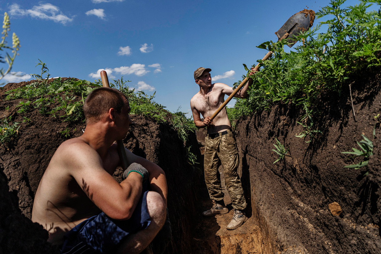 Oekraïense militairen graven loopgraven nabij de frontlijn in de Donbas. Beeld AP
