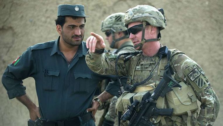 Een Amerikaanse officier in gesprek met een lid van de Afghaanse Nationale Politie. Beeld afp