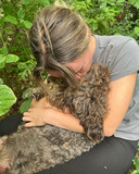 Amber Hollemans, nét herenigd met haar hondje, in de bosjes.