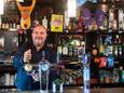 Oud-wethouder John van Vugt achter de bar in café de Tijd. 'Ik denk dat het biertjes tappen via mijn opa in mijn genen is geslopen'.