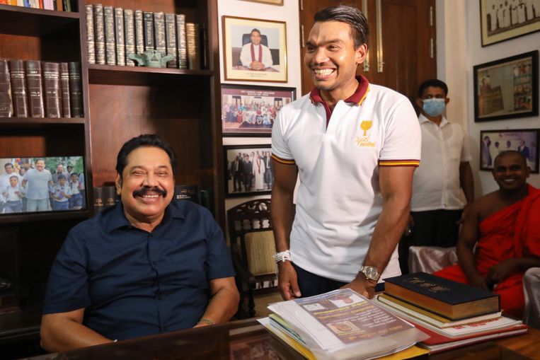 De nieuwe premier Mahinda Rajapaksa en zijn zoon Namal Rajapaksa in hun huis in Beliatte op Sri Lanka. Beeld EPA