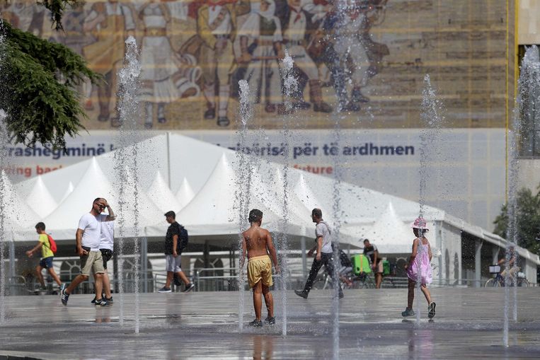Kinderen zoeken afkoeling in Tirana, de hoofdstad van Albanië. De temperatuur steeg gisteren tot 39°C.  Beeld AFP