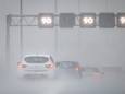 Foto ter illustratie. Auto's rijden langzaam op de snelweg door hevige regenval.