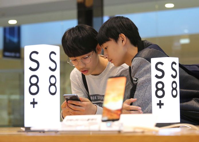 Jonge Zuid-Koreanen bekijken een Samsung Electronics Galaxy S8 Plus-smartphone in een winkel in hoofdstad Seoel.