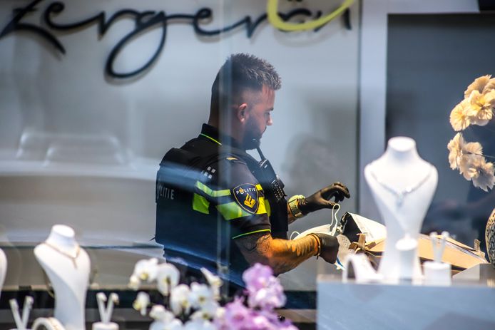 Archiefbeeld na de overval: een agent doet onderzoek bij de juwelier in Rotterdam-Kralingen.