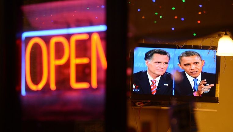 Een tv-scherm in een restaurant in Los Angeles toont het kandidatendebat. Beeld afp