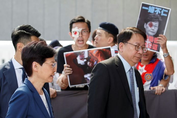 Hong Kong's regeringsleider Carrie Lam wandelt langs demonstranten in Hongkong.