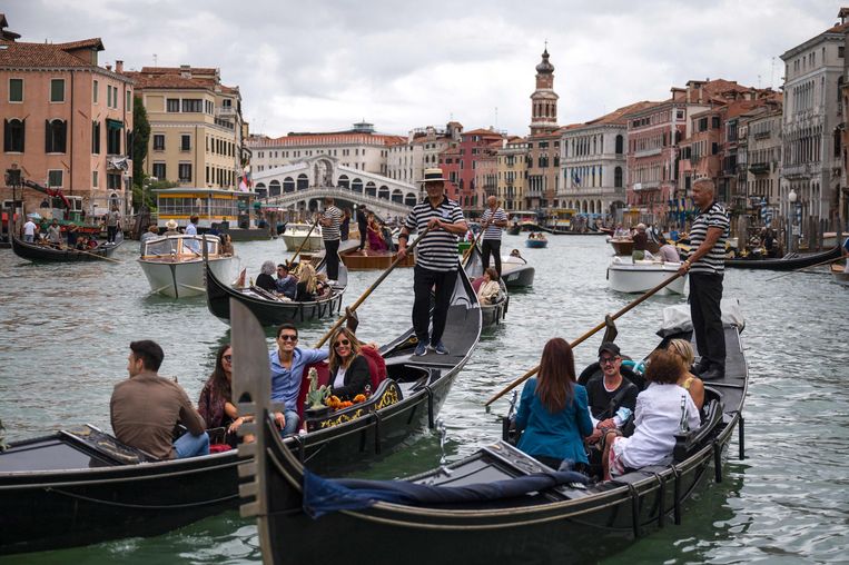 Toeristen op een gondel nabij de Rialtobrug in Venetië. Sinds de toeristen weer terug zijn, heeft de stad haast gemaakt met het plan voor het toegangssysteem. Beeld AFP