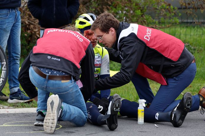 Taco van der Hoorn zit bloedend op het asfalt. Dokter Mathieu Vermeersch (rechts): "Er zat niets anders op dan zijn hoofdwonde ter plaatste dicht te nieten."