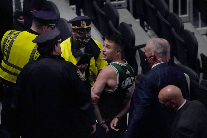 Een Celtics-fan wordt afgevoerd door de politie nadat hij Kyrie Iving met een flesje water heeft bekogeld.