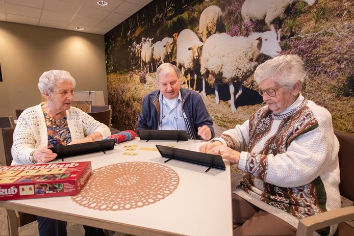 Bewoners Iet Elbers, Pleun de Heer en Gé Oosterhoff (v.l.n.r.) spelen een spelletje Rummikub in De Schaapskooi, de nieuwe ontmoetingsruimte in appartementencomplex Mandala.