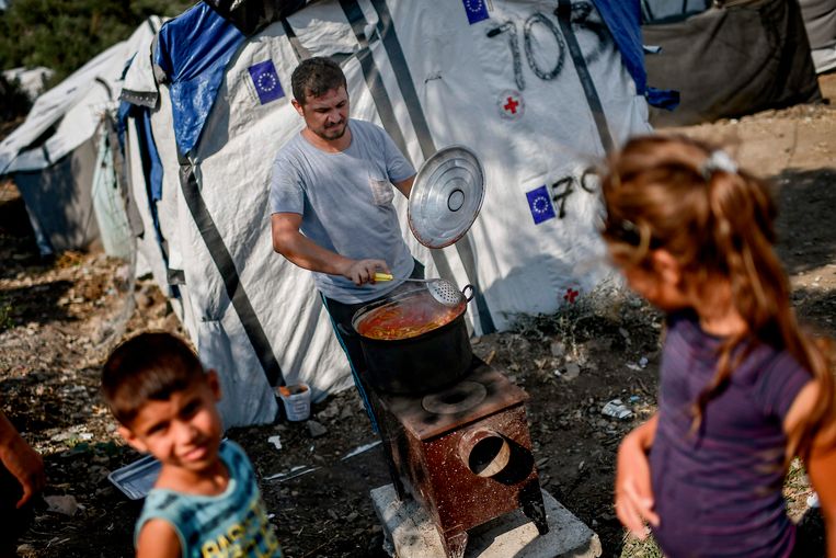 Een gevluchte familie uit Syrië maakt eten klaar in een kamp naast het vluchtelingenkamp Moria op Lesbos, 5 augustus 2018.  Beeld AFP