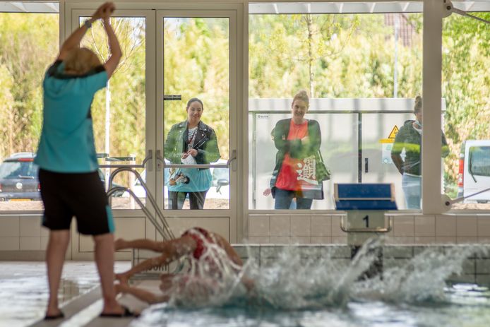 De vraag hoe proportioneel alle coronamaatregelen zijn, klinkt steeds luider. Hier staan ouders voor het raam tijdens een zwemles. Foto: Isabelle van der Voorn - Fotodrent