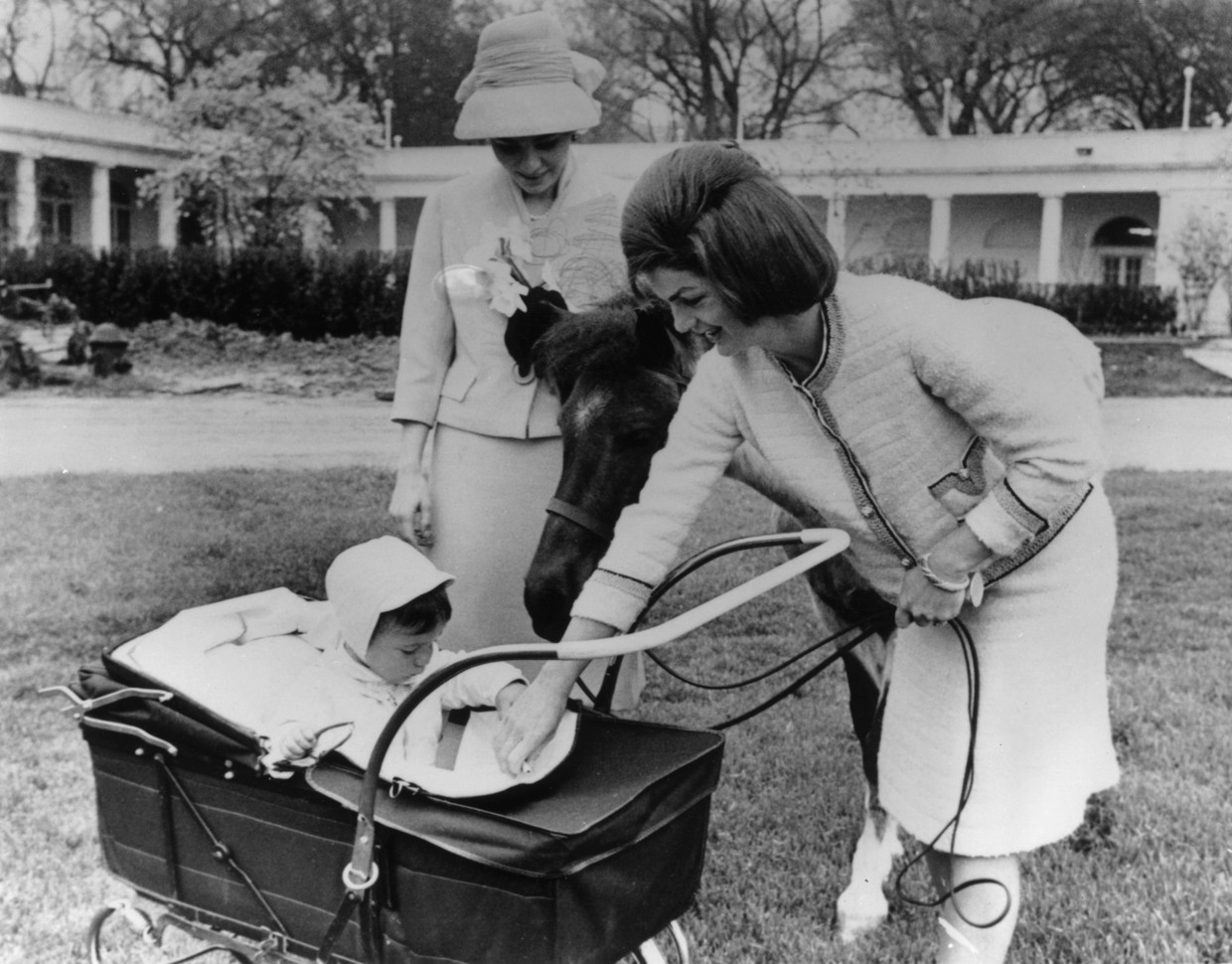 Jackie Kennedy menunjukkan putranya John kepada Farah Diba.  Gambar Getty