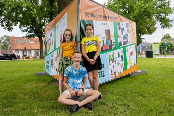 Kinderen van de basisschool in Gastel hebben meegedacht in het kader van de dorpsvisie. Hun wensen zijn te zien op drie grote doeken op het Cornelisplein. Op de foto staan Silke, Roos en Sven.