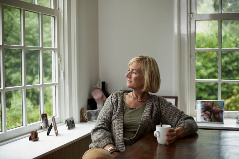 Thoughtful senior woman having coffee at table in cottage Beeld Getty Images