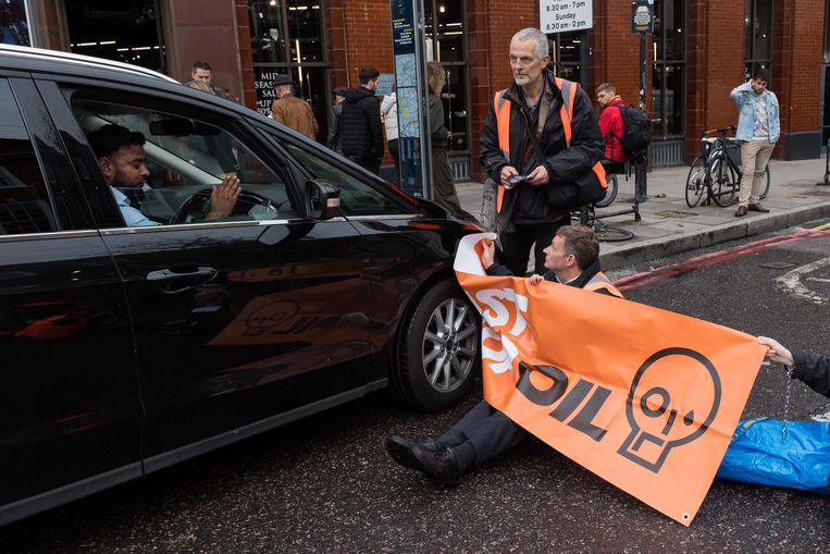 Een actievoerder van Just Stop Oil blokkeert de weg in Londen. Beeld Anadolu Agency via Getty Images