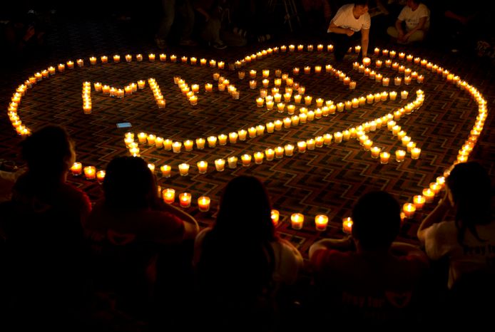 Nabestaanden van Chinese passagiers aan boord van de verdwenen vlucht MH370 branden kaarsen voor hun geliefden in Beijng.