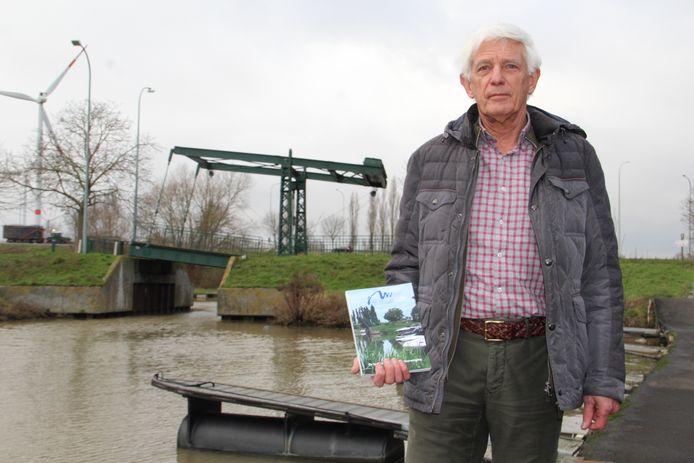 Voorzitter Jos Bilcke van de Izegemse Watersportvereniging bij hun jachthaven in Kachtem en met het boek dat het vijftigjarig bestaan viert.