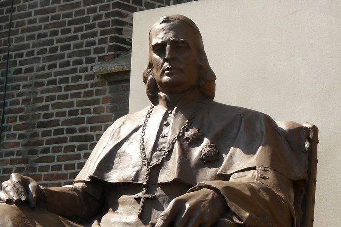 Het in 1933 vervaardigde bronzen beeld van Joannes Zwijsen, gezeten tegen de zijkant van de Heikese kerk in Tilburg, met uitzicht op zijn eigen Bisschop Zwijsenstraat.