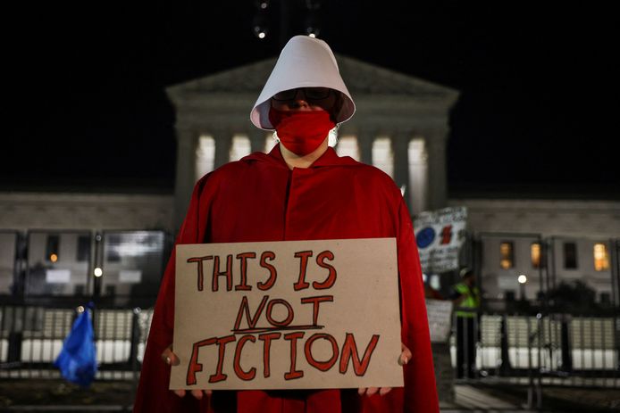 Een demonstrant draagt een Handmaid's Tale-gewaad bij een protest tegen het afschaffen van het recht op abortus.