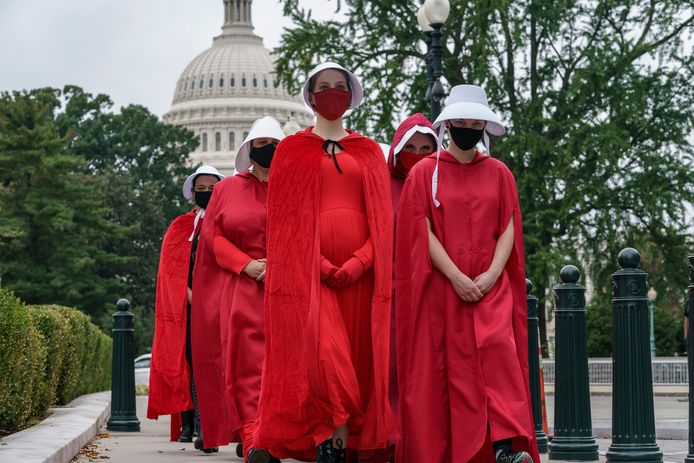 Activisten die tegen de benoeming van Amy Coney Barrett zijn, wandelen verkleed als personages van 'The Handmaid's Tale' bij het hooggerechtshof in Washington.