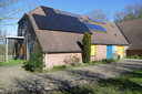 Een kleiner aantal zonnepanelen zoals hier op het dak bij de scouting is nog steeds mogelijk. Pas als het om 150 zonnepanelen of meer gaat, wordt aansluiting op het stroomnet een probleem.