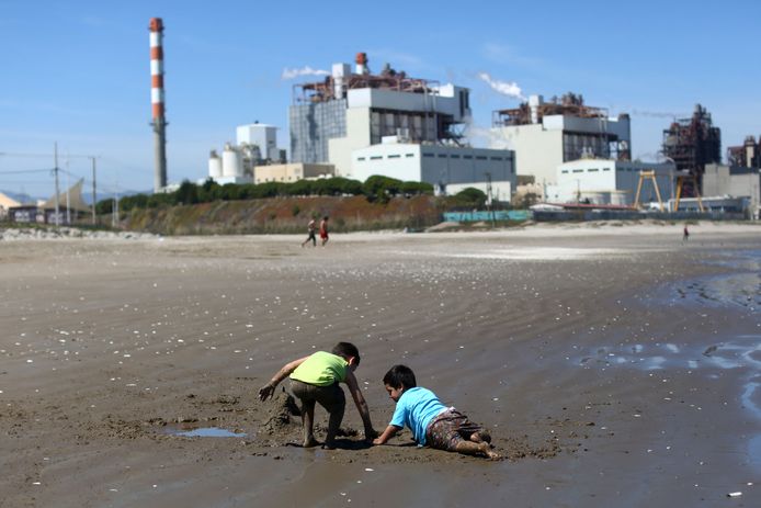 Spelende kinderen op het strand naast een thermo-elektrische centrale in Puchuncavi.