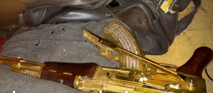 Bij de doorzoeking werd onder meer een gouden replica van een Kalasjnikov ingenomen.