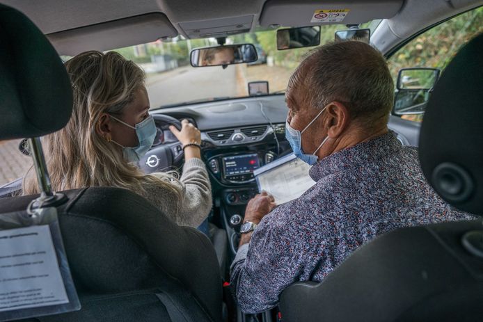 Een rij-instructeur en een leerling dragen mondkapjes tijdens het lessen in Nijmegen. Het CBR stelt het dragen van mondkapjes tijdens rijlessen verplicht, vanwege het groeiende aantal coronabesmettingen.