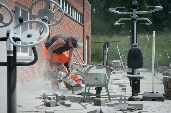 Een arbeider slijpt enkele stenen tussen de toestellen.