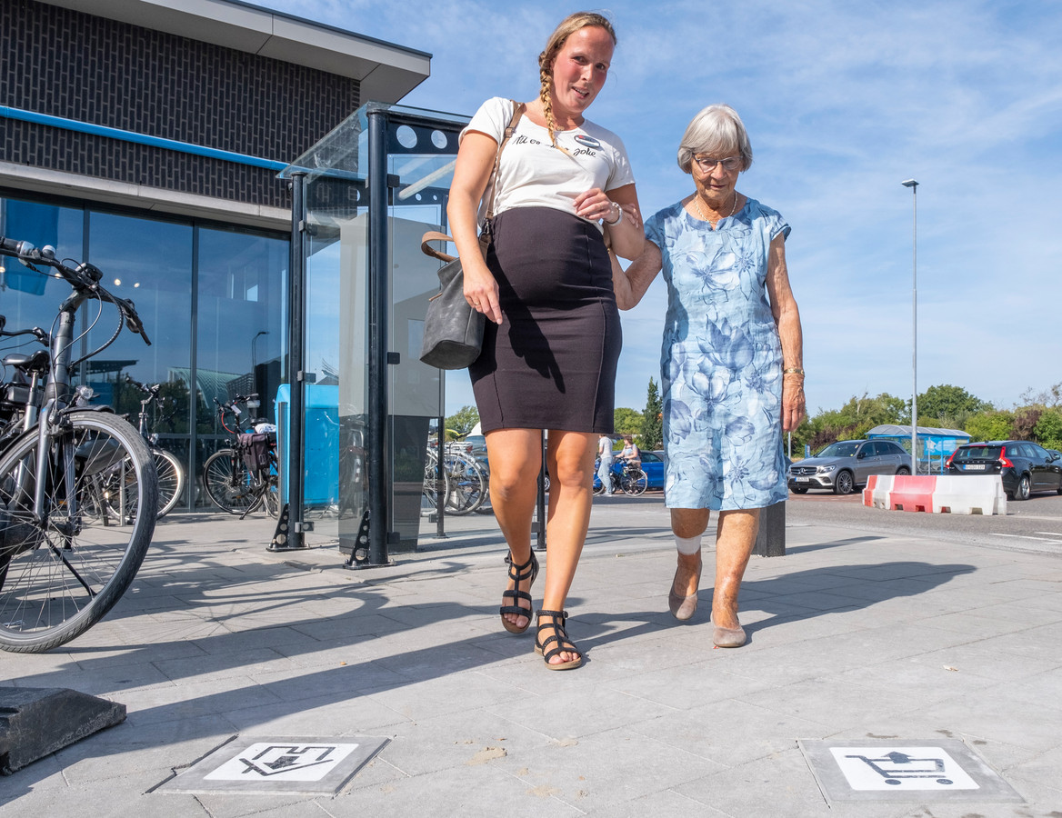 Tamara Wijkhuijs van Simnia en bewoonster Alie volgen de tegels op de dementievriendelijke route.