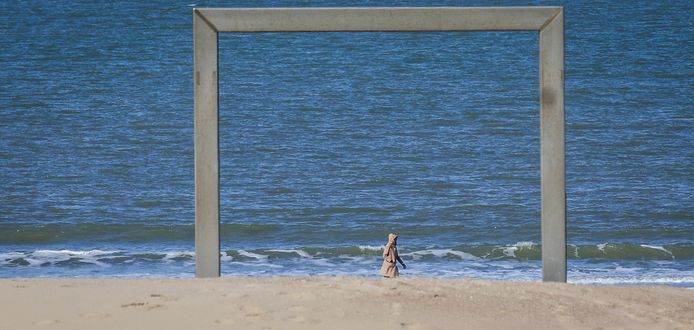 Een eenzame wandelaar op het strand van Knokke.