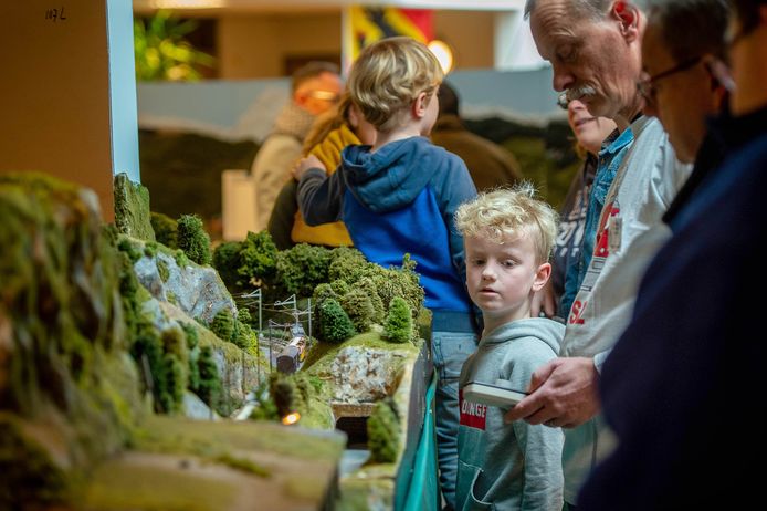 Tentoonstelling van een smalspoormodelbaan naar Zwitsers voorbeeld in Wijchen afgelopen weekend. Felix Pots (8) kijkt aandachtig hoe een lid van de Gennepse vereniging de trein weer laat rijden.