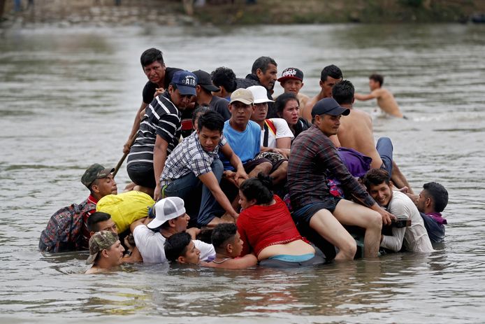 Hondurese migranten steken de rivier tussen Mexico en Guatemala over.