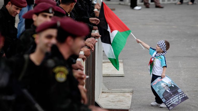 En Palestijnse jongen viert de terugkeer van president Abbas in Ramallah. Beeld REUTERS