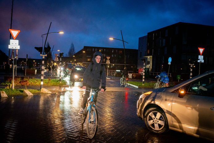 Auto's die zich tussen overstekende scholieren heen wurmen.