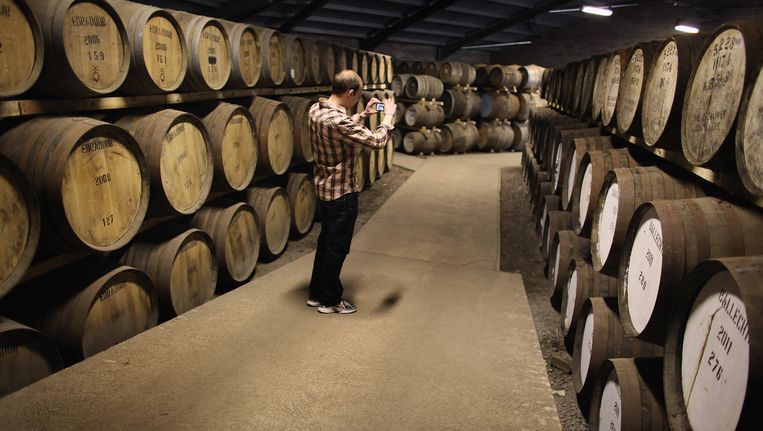 Een toerist in een opslagruimte voor whiskyvaten in Pitlochry Beeld Getty Images