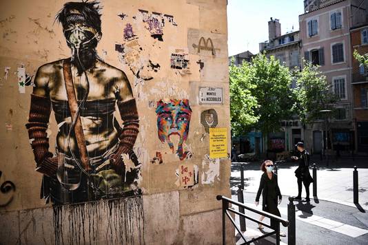 Een graffitiwerk van een man met mondmasker in Marseille. 