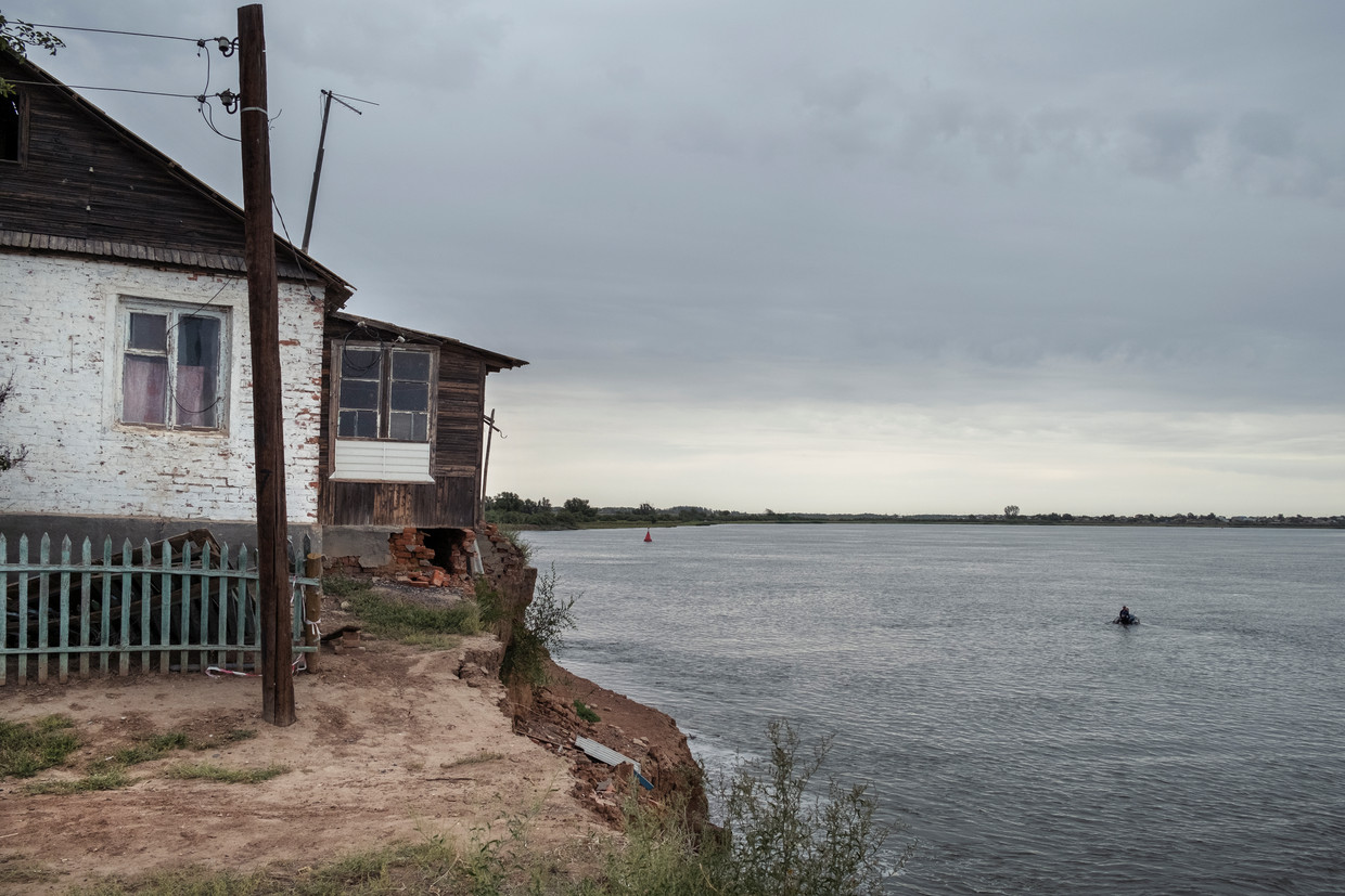 Een huis dat gedeeltelijk afbrokkelt in de Wolga in Sergiëvka, een vissersdorpje in de provincie Astrachan. Beeld Arthur Bondar