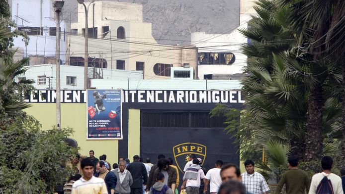 Bezoekers van gevangenen lopen tijdens het bezoekuur over de toegangsweg van de beruchte Castro Castro gevangenis (achtergrond) buiten de Peruaanse hoofdstad Lima.